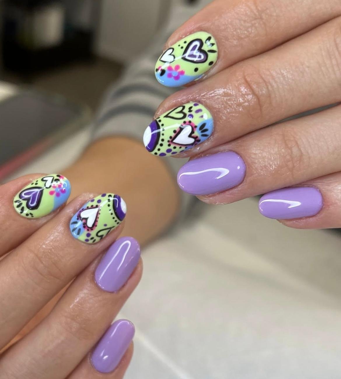 uñas decoradas en tonos morado y verde